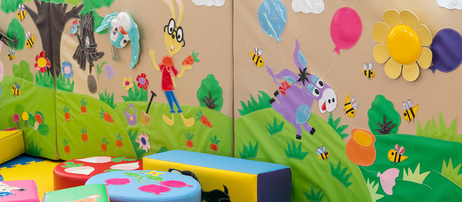 Sala de juegos con mural infantil y colchonetas