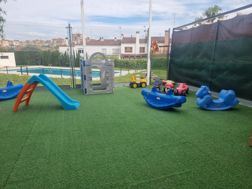 Patio exterior con tobogán y juegos de la escuela El Sol en Mairena del Aljarafe